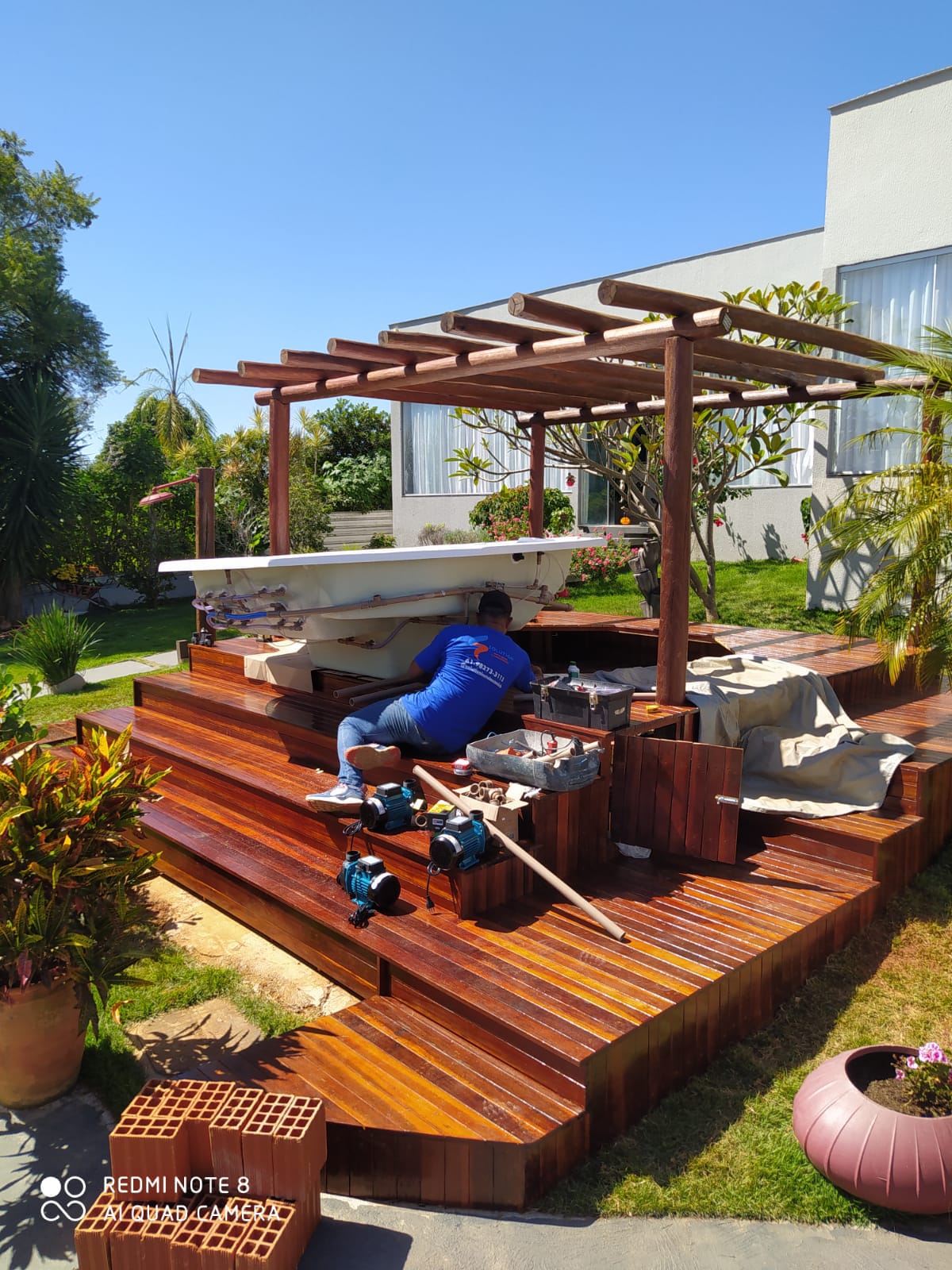 Ambiente com deck de madeira e hidromassagem integrada ao jardim.