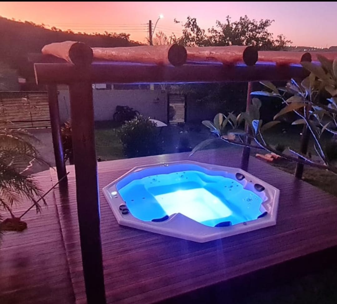 Área externa com hidromassagem e pergolado finalizados.